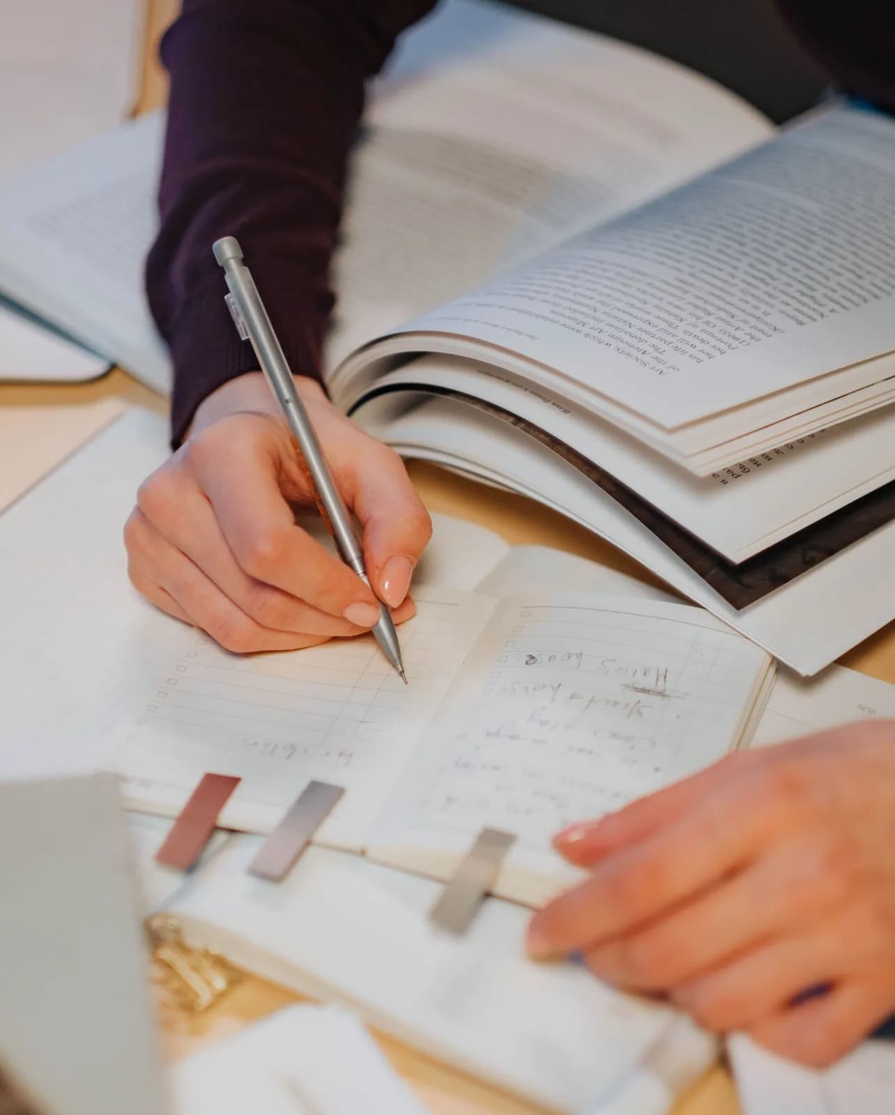 A student writing a study to-do list with checkboxes in a planner